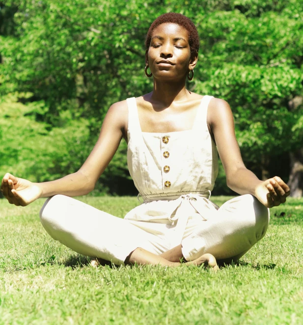a woman sitting in the grass doing yoga, by Everett Warner, pexels, renaissance, afrocentric mysticism, 2 0 0 0's photo, symmetrical pose, praying