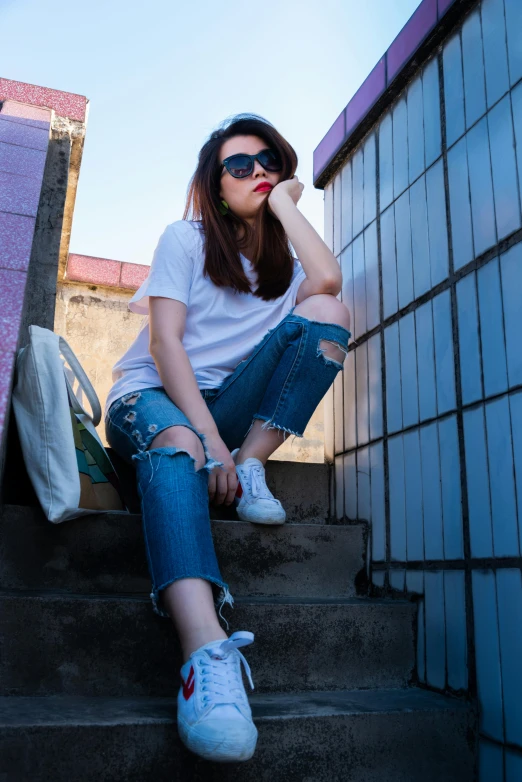 a woman sitting on the steps of a building, white shirt and blue jeans, trending on r/streetwear, avatar image, asian women