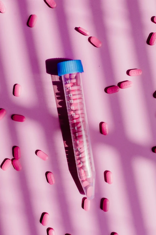 a tube of pink pills on a pink surface, by Sebastian Vrancx, unsplash, conceptual art, purple mullet, in a lab, instagram picture, ilustration