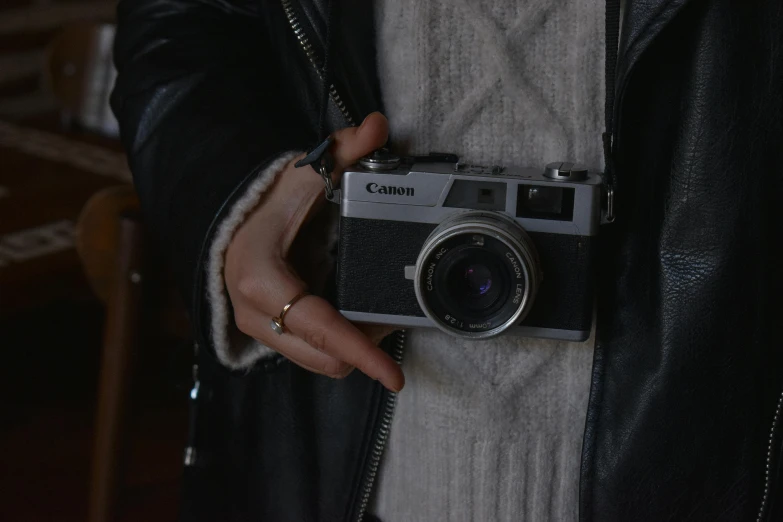 a close up of a person holding a camera, inspired by Elsa Bleda, unsplash contest winner, canon a1, casually dressed, cynthwave, 1970s cinema camera