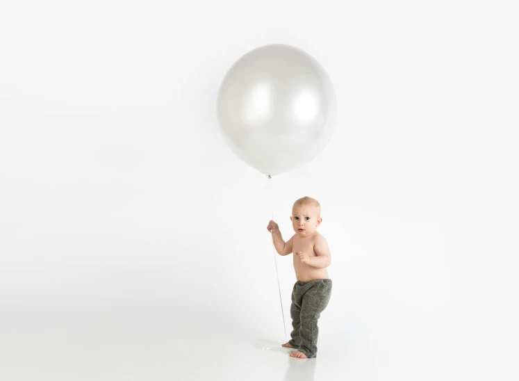 a baby standing in front of a white balloon, chrome silver, full product shot, grey, super wide