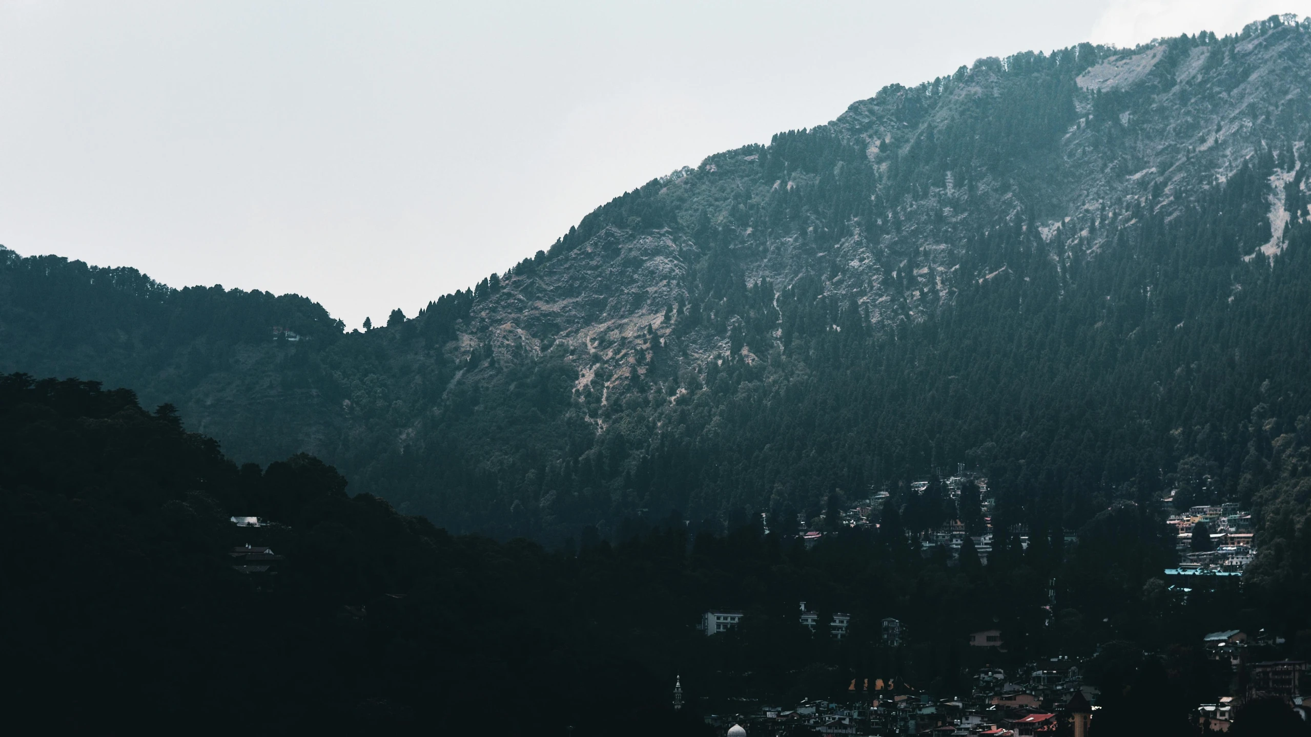 a body of water with a mountain in the background, dark pine trees, breathtaking himalayan landscape, city view, unsplash 4k