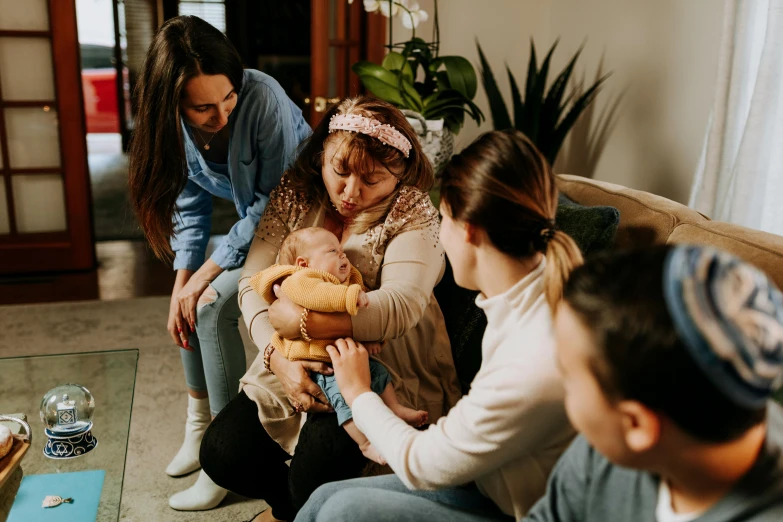 a group of people sitting on a couch holding a baby, by Emma Andijewska, trending on pexels, grieving, avatar image, lesbian, worksafe. instagram photo