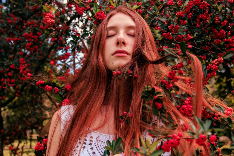 a woman with long red hair standing in front of a tree, an album cover, inspired by Elsa Bleda, pexels contest winner, made of flowers and berries, anya taylor joy, maxim sukharev, unsplash contest winning photo