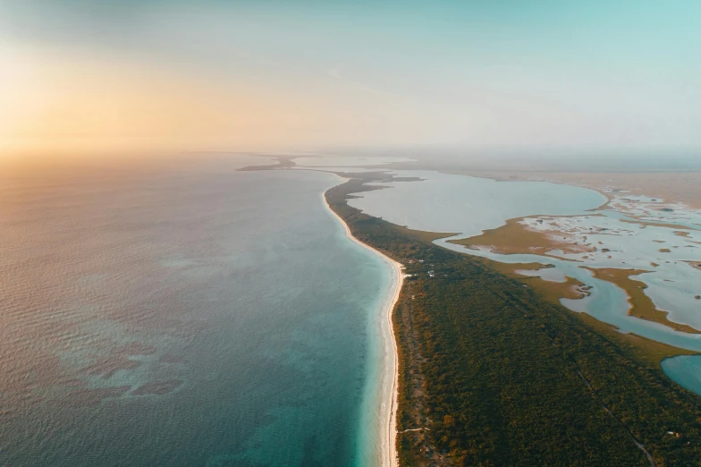 an aerial view of an island in the middle of the ocean, by Peter Churcher, unsplash contest winner, hurufiyya, which shows a beach at sunset, songlines, long view, carribean turquoise water