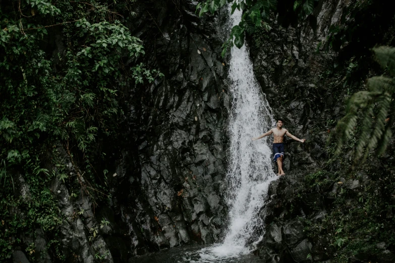 a man that is standing in front of a waterfall, by Jessie Algie, pexels contest winner, philippines, swimming, solo hiking in mountains trees, slide show