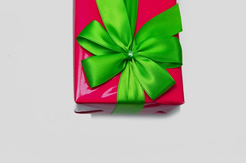 a pink gift box with a green bow, by Eden Box, pexels contest winner, on a gray background, eye - level view, green: 0.5, highly polished