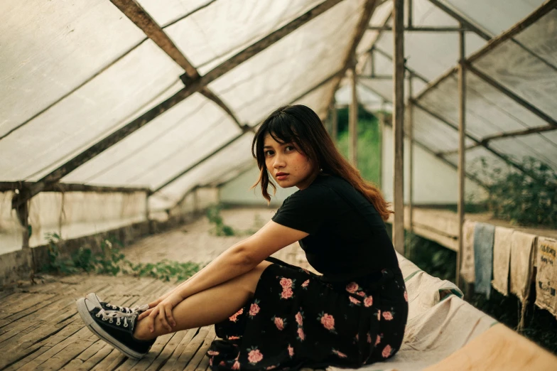 a woman sitting on a bench in a greenhouse, an album cover, pexels contest winner, malaysian, looking to camera, sitting on the floor, profile image