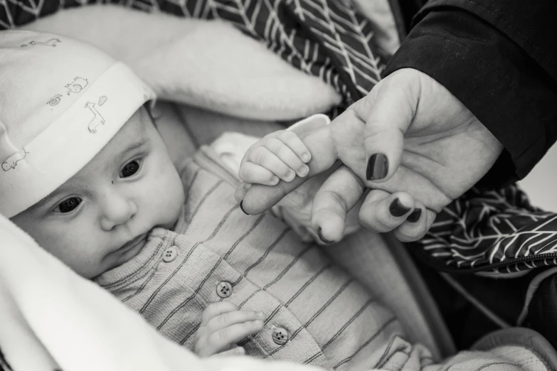 a black and white photo of a baby in a stroller, by Romain brook, pexels, white bandages on fists, family photo, high angle close up shot, 8 k photo