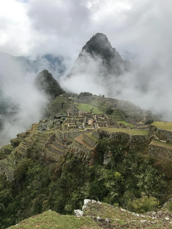 a group of people standing on top of a mountain, machu picchu, mist below buildings, avatar image