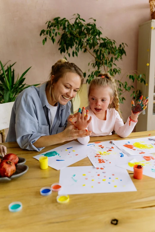 a woman and a little girl sitting at a table, a child's drawing, pexels contest winner, finger painting, joyful people in the house, paper cutouts of plain colors, dot painting