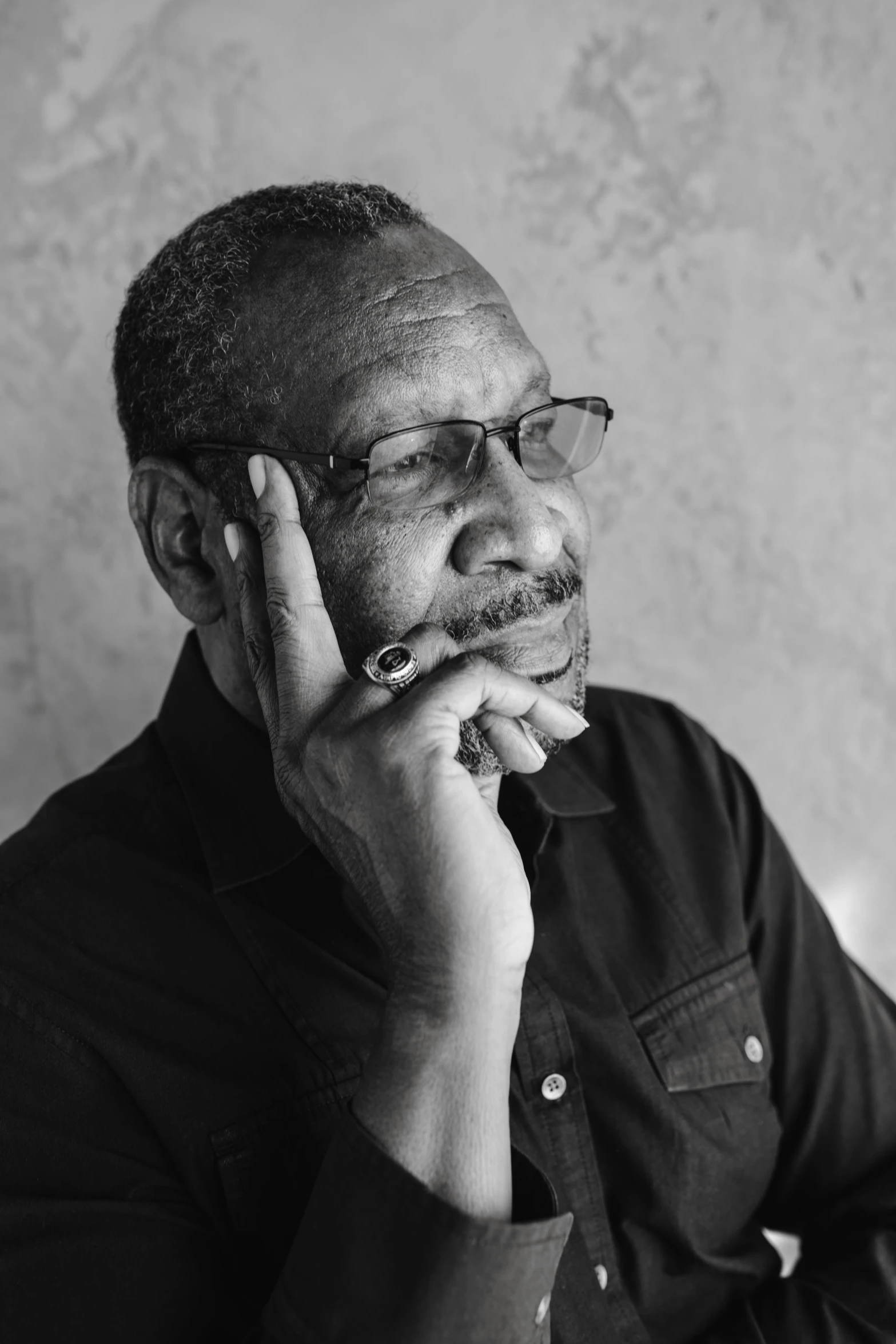 a black and white photo of a man talking on a cell phone, inspired by James E. Brewton, black arts movement, man with glasses, holding cigar, ((portrait)), instagram photo