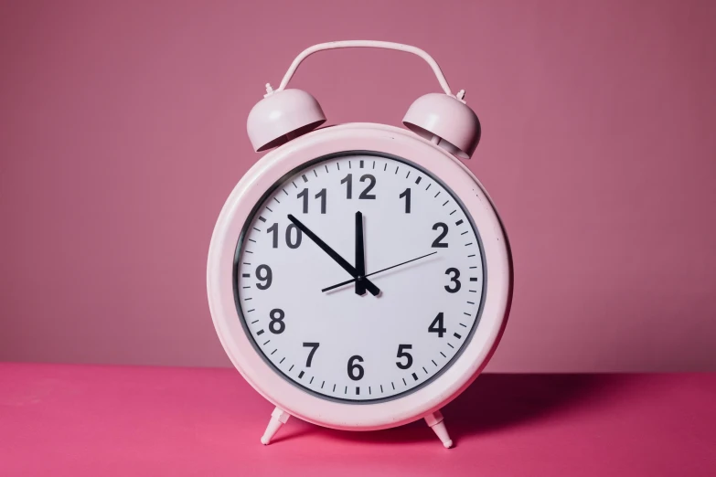 a pink alarm clock on a pink surface, pexels, ((pink)), giant clock, amanda clarke, aged 2 5