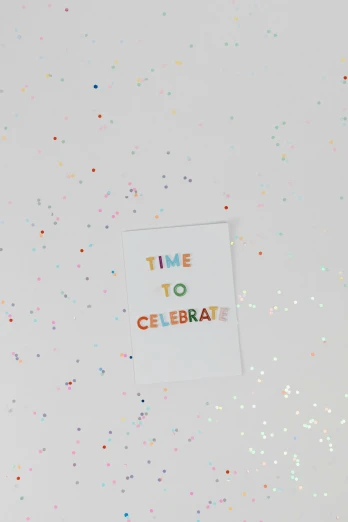 there is a sign that says time to celebrate, by Nicolette Macnamara, trending on unsplash, holo sticker, greeting card, detail shot, flat lay