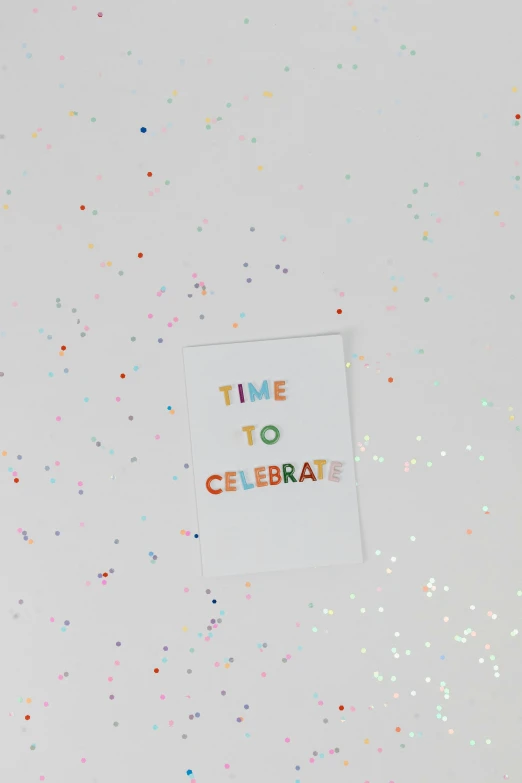 there is a sign that says time to celebrate, by Nicolette Macnamara, trending on unsplash, holo sticker, greeting card, detail shot, flat lay