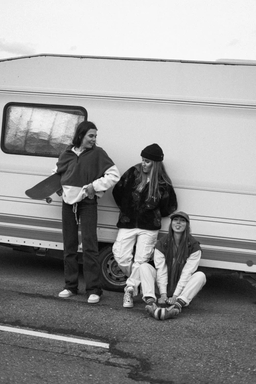 a group of people standing next to a white van, a black and white photo, by Nathalie Rattner, renaissance, girls resting, next to an rv, nostalgic 8k, !! low contrast!!