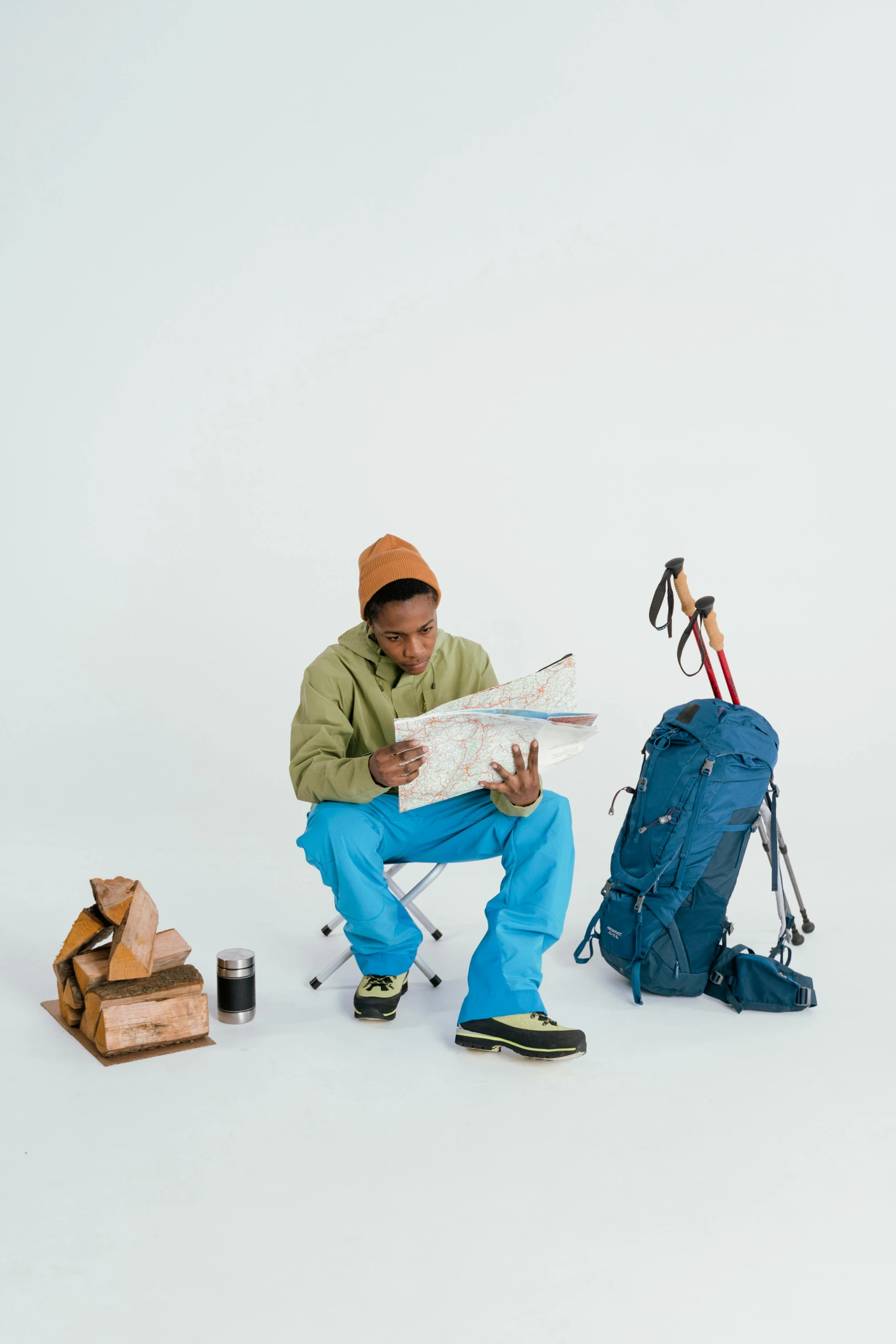 a man sitting on top of a chair next to a pile of luggage, a picture, wearing adventure gear, tyler the creator, map, product introduction photo