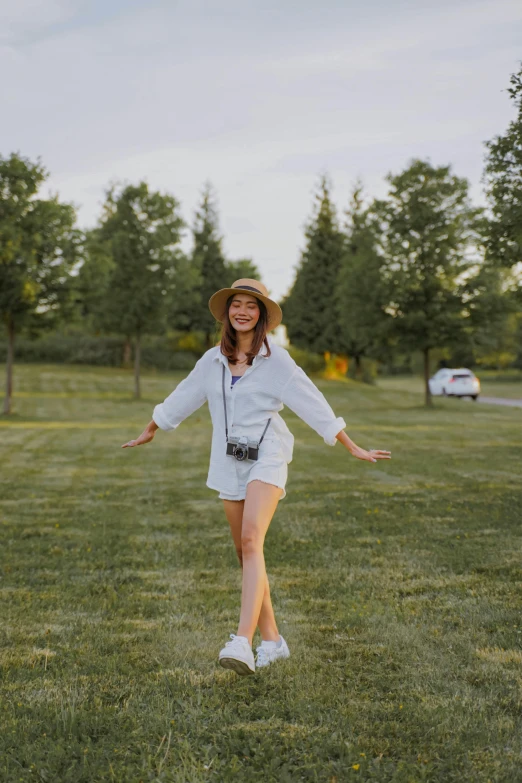 a woman standing on top of a lush green field, white straw flat brimmed hat, wearing white sneakers, posing for a picture, joy ang