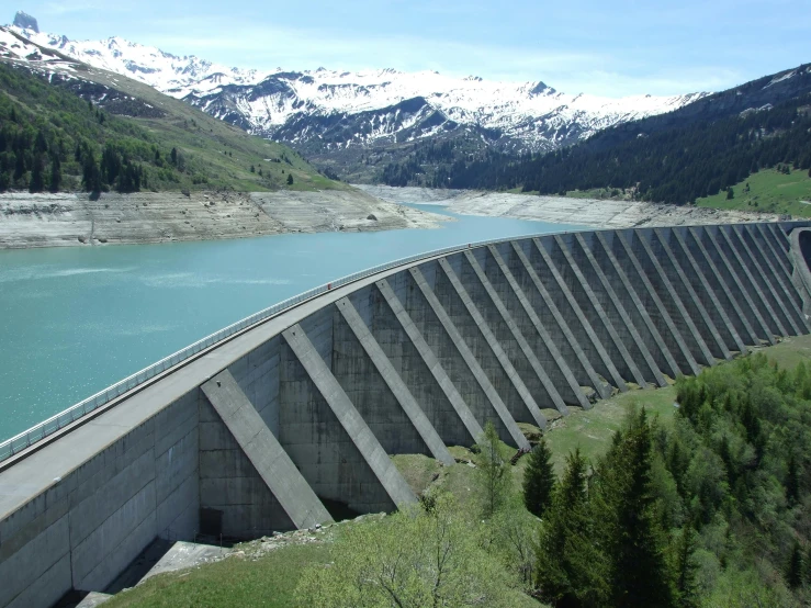 a large body of water with mountains in the background, concrete walls, alpes, overflowing energy, civil engineer