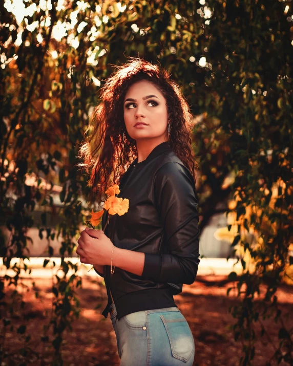a beautiful young woman standing under a tree, inspired by Elsa Bleda, pexels contest winner, wearing a leather flight jacket, golden hour 8 k, beautiful iranian woman, attractive photo