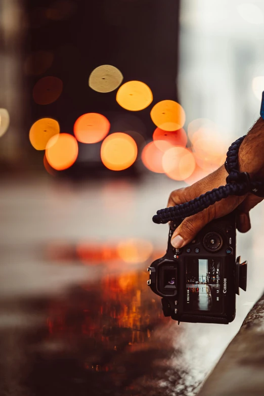 a close up of a person holding a camera, pexels contest winner, bokeh lights, colour film street photography, car photography, half - length photo