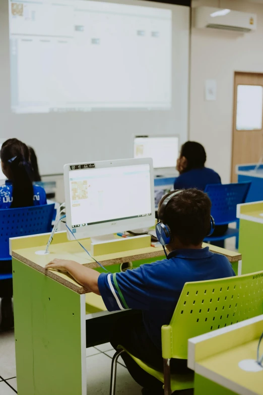 a group of people sitting at desks in front of computers, a digital rendering, pexels, computer art, wearing a headset, boys, indonesia, mobile learning app prototype