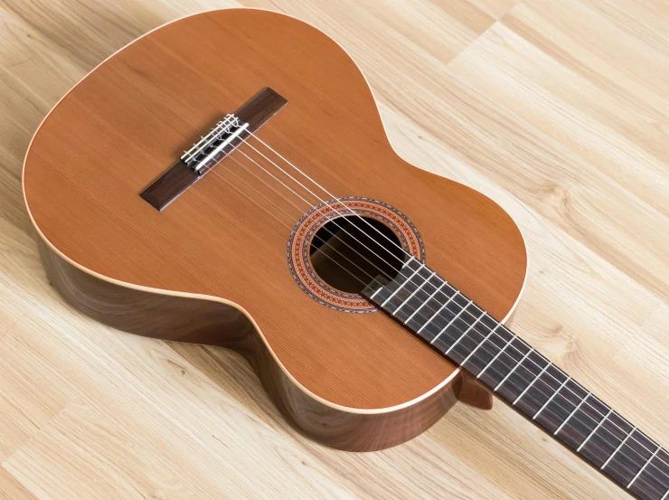 a close up of a guitar on a wooden floor, inspired by Carlos Enríquez Gómez, arabesque, natural wood top, thumbnail, square, student