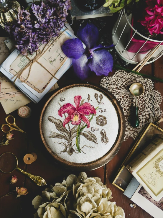 a table topped with lots of different types of flowers, a cross stitch, by Zofia Stryjenska, trending on pexels, an orchid flower, victorian alchemists, brown and magenta color scheme, illustration »