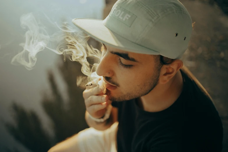 a man in a hat smokes a cigarette, inspired by Elsa Bleda, trending on pexels, pot leaf, male with halo, college, profile pic