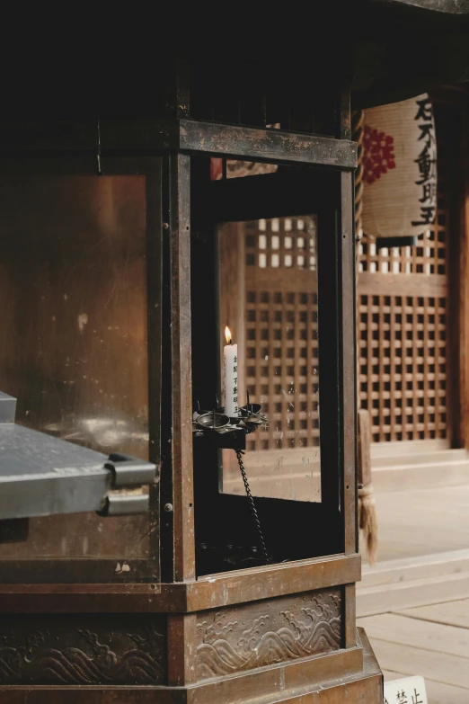 a wooden lantern sitting on top of a sidewalk, inspired by Itō Jakuchū, unsplash, sōsaku hanga, inside the sepulchre, interior of a small, mechanical detail, holding a candle