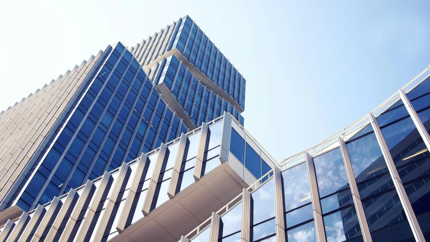 a couple of tall buildings next to each other, pexels contest winner, modernism, full of clear glass facades, upwards, blue and clear sky, stacked image