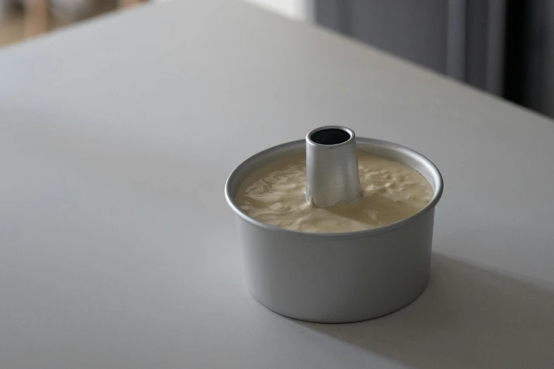 a close up of a tin of food on a table, baking a cake, steel collar, soft volume absorbation, silver，ivory