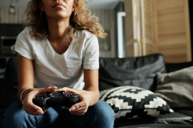 a woman sitting on a couch holding a video game controller, pexels, instagram post, struggling, gaming room, nvidia promotional image