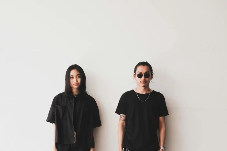 a couple of men standing next to each other, a portrait, inspired by Wang Duo, tumblr, minimalism, wearing a black shirt, older sister vibes, press shot, thawan duchanee