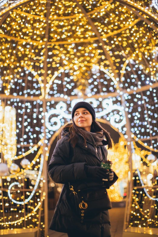 a woman standing in front of christmas lights, symbolism, in a city square, profile image