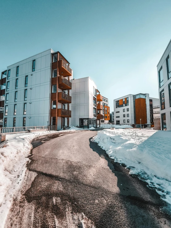 a street filled with lots of snow next to tall buildings, pexels contest winner, modernism, small scandinavian!!! houses, high-quality render, cold as ice! 🧊, wide angle exterior 2022