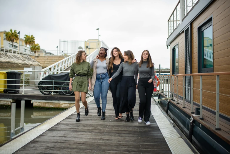 a group of women standing next to each other on a dock, an album cover, by Nina Hamnett, pexels contest winner, happening, college students, walking, pr shoot, on a boat