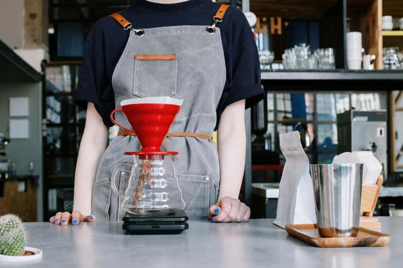 a person that is standing in front of a counter, by Julia Pishtar, trending on unsplash, starbucks aprons and visors, payne's grey and venetian red, dripping blue natural iwakura, cone shaped