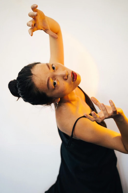 a woman in a black dress posing for a picture, inspired by Fei Danxu, arabesque, with arms up, bao pham, profile image, asian descent