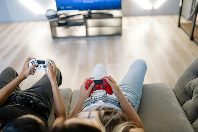 two people sitting on a couch playing a video game, by Julia Pishtar, shutterstock, style game square enix life, top down shot, playstation 6, colour photo