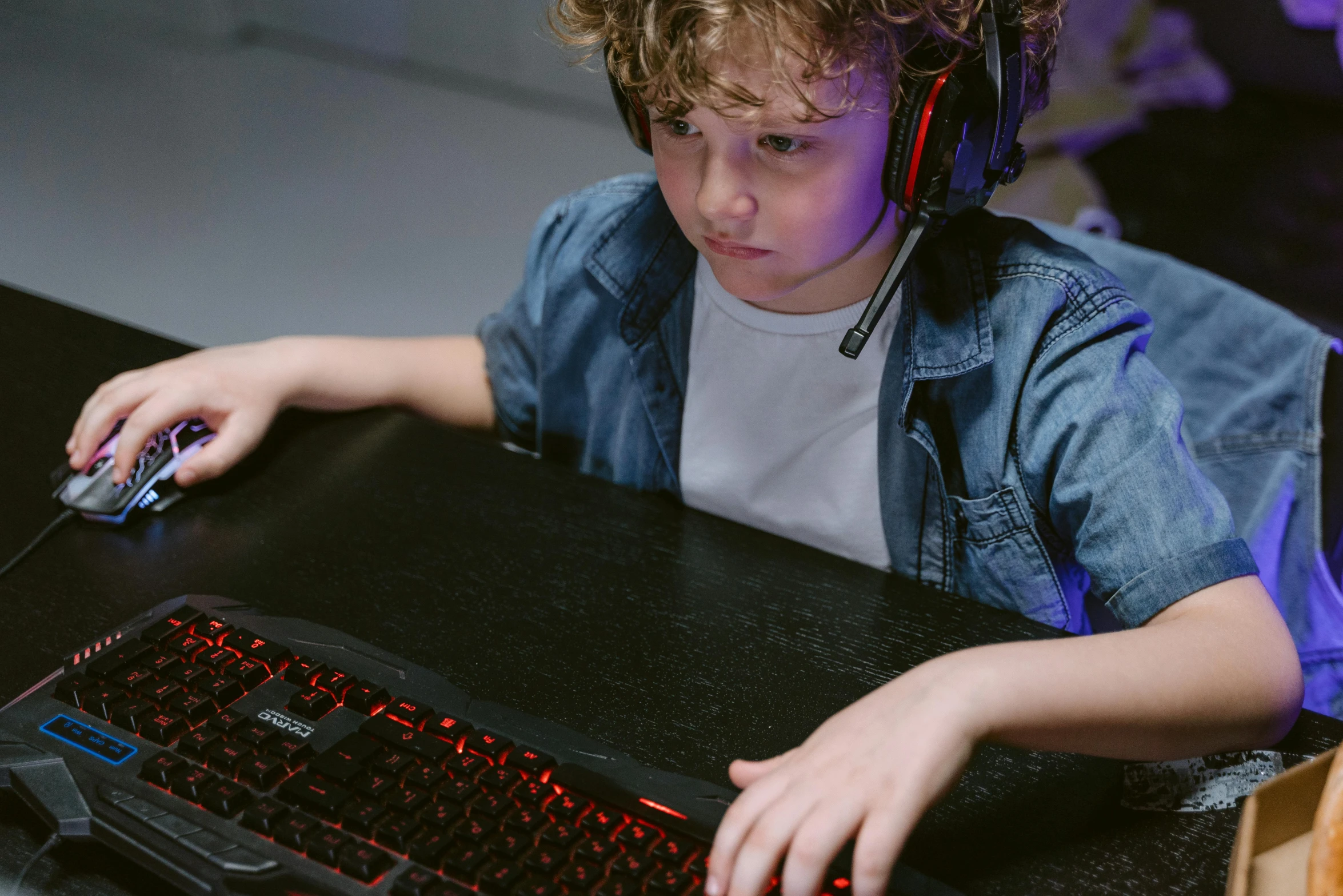 a young boy sitting at a desk with a keyboard and headphones, pexels, in-game, team ibuypower, half image, blank