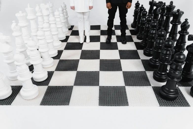 a man and a woman standing next to a giant chess board, an album cover, by Marina Abramović, trending on unsplash, interactive art, white floor, yeezy collection, product introduction photo, style game square enix life