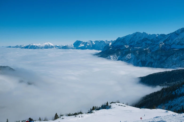 a group of people riding skis down a snow covered slope, by Matthias Weischer, pexels contest winner, romanticism, above low layered clouds, blue, distant valley, avatar image