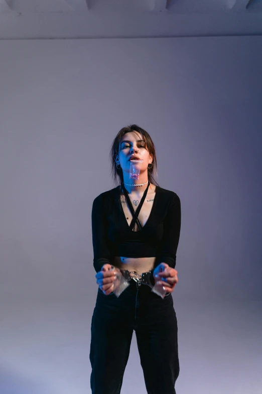 a woman holding a video game controller in her hands, an album cover, inspired by Elsa Bleda, antipodeans, wearing black choker, in a photo studio, intimidating stance, 2019 trending photo