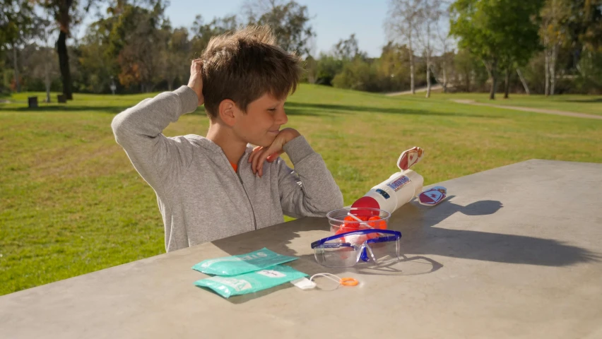 a boy sitting at a table with a toy airplane, toothpaste blast, pod racer, fluid bag, ready to model