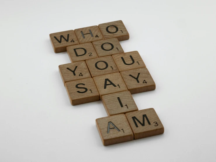 a scrabble that says who do you say i am?, a jigsaw puzzle, by Sylvia Wishart, letterism, alessio albi, award - winning brand agency, wooden statue, yo