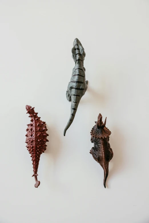 a group of seahorses sitting on top of a white surface, a surrealist sculpture, unsplash, vicious snapping alligator plant, textured plastic, wall art, spike shell