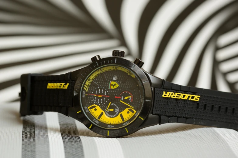 a close up of a watch on a bed, inspired by Francesco Furini, trending on pexels, pop art, black and yellow tracksuit, ferrari, spitfire, formula 1