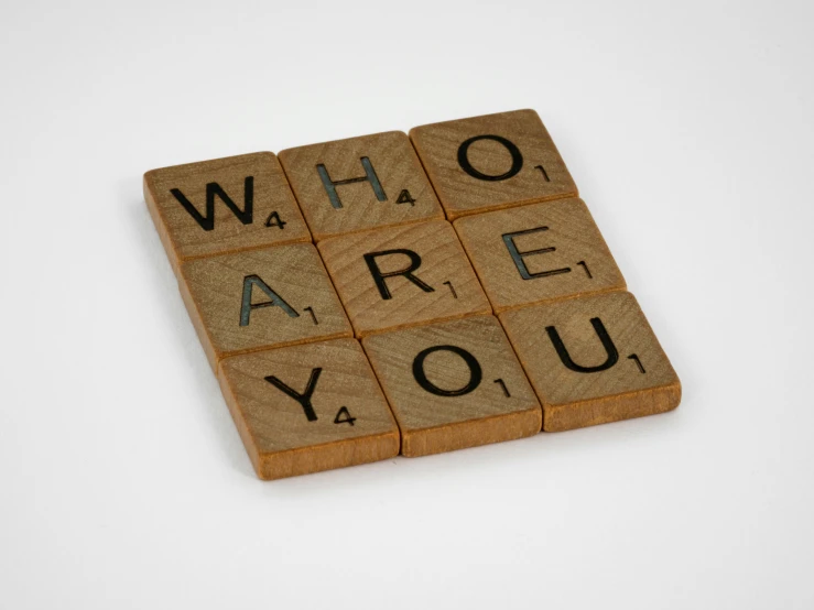 a scrabble that says who are you?, wood effect, official product photo, ffffound, white