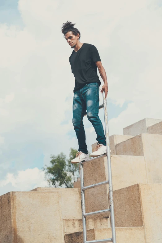 a man standing on top of a set of stairs, jean pants, outlive streetwear collection, neymar jr, sky - high view